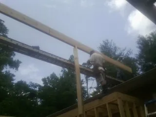 Carpenter setting a ridge beam over a new addition frame — Ice Dam Removal by Roofing Brothers in Tatamy