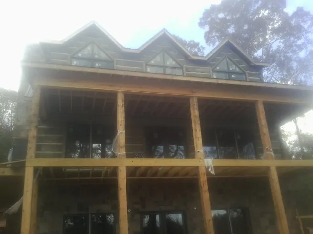 Dormers and porch framing on a large log home under construction — Roof Coating work by our crew in Tatamy