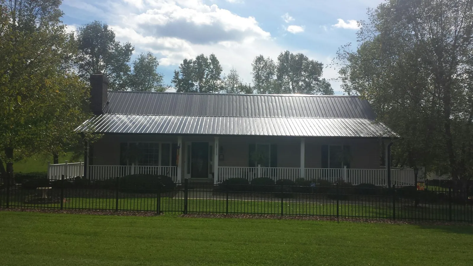 Gray metal roof on a brick ranch with a full width front porch — Gutter Guard Installation work by our crew in Tatamy