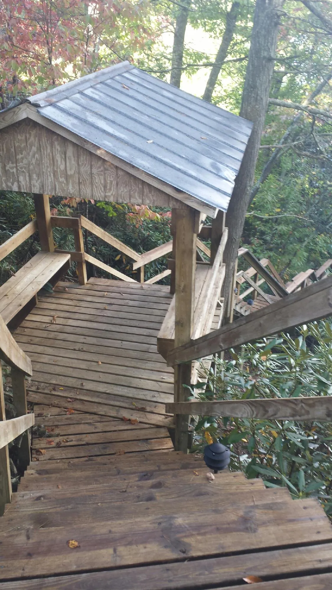 Metal roofed shelter over wooden steps on a wooded walkway — Skylight Repair & Installation work by our crew in Tatamy