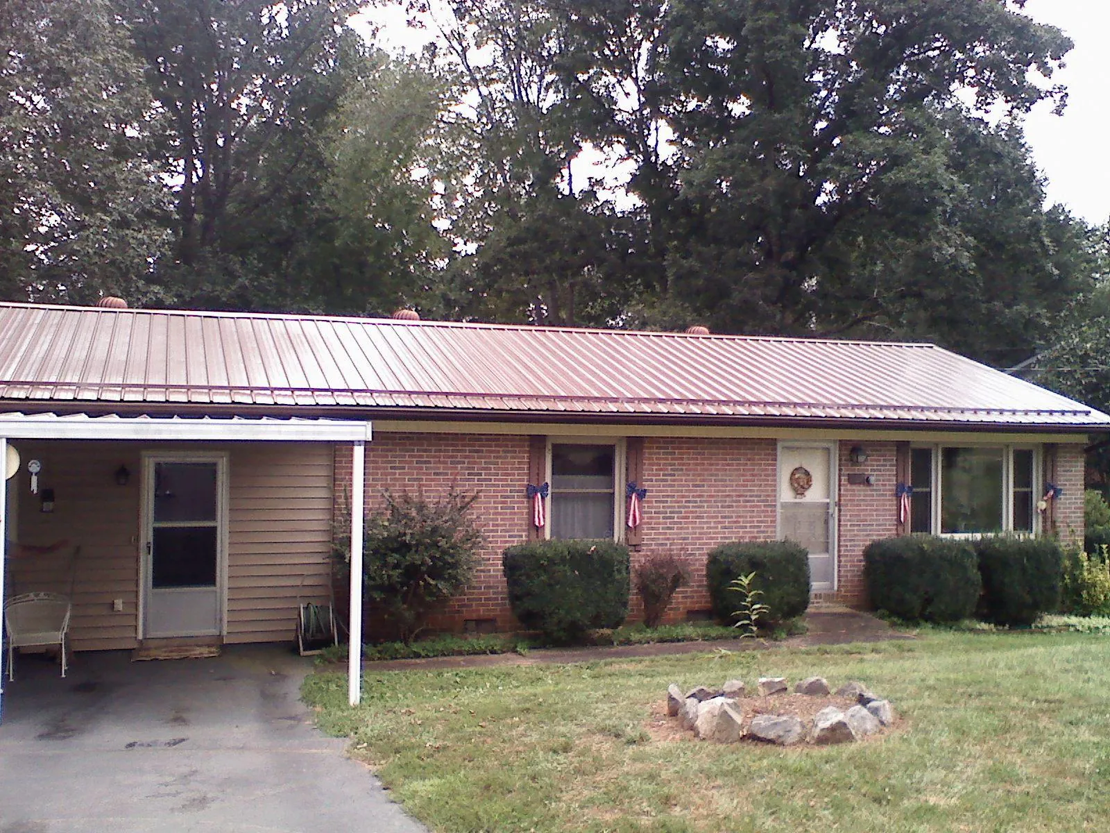 Bronze metal roof and carport on a brick ranch home — Roof Repair work by our crew in Tatamy